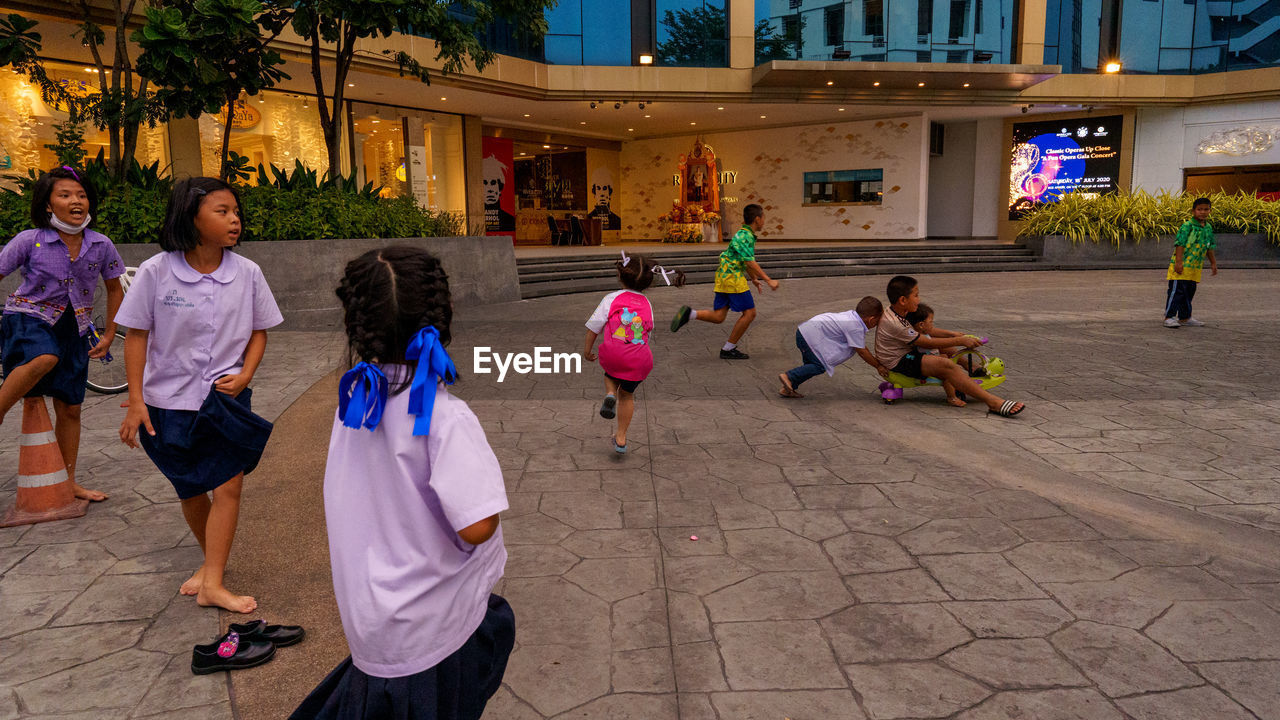 GROUP OF PEOPLE IN FRONT OF BUILDINGS