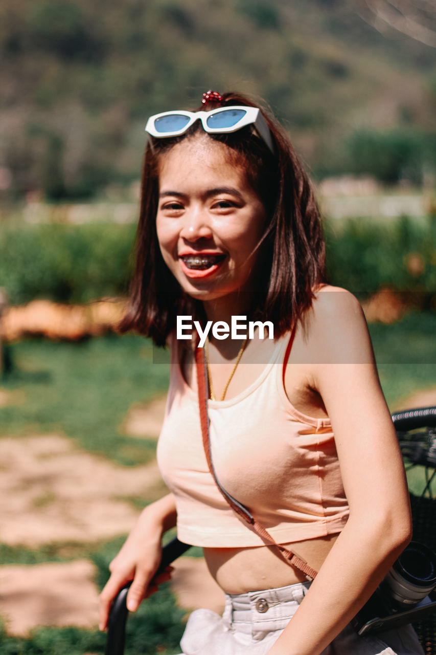 Portrait of smiling young woman wearing sunglasses