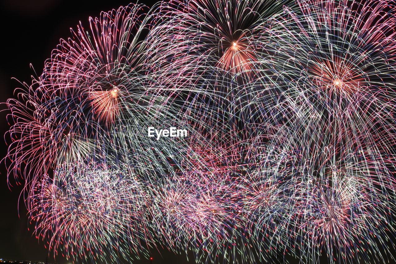 Low angle view of firework display at night