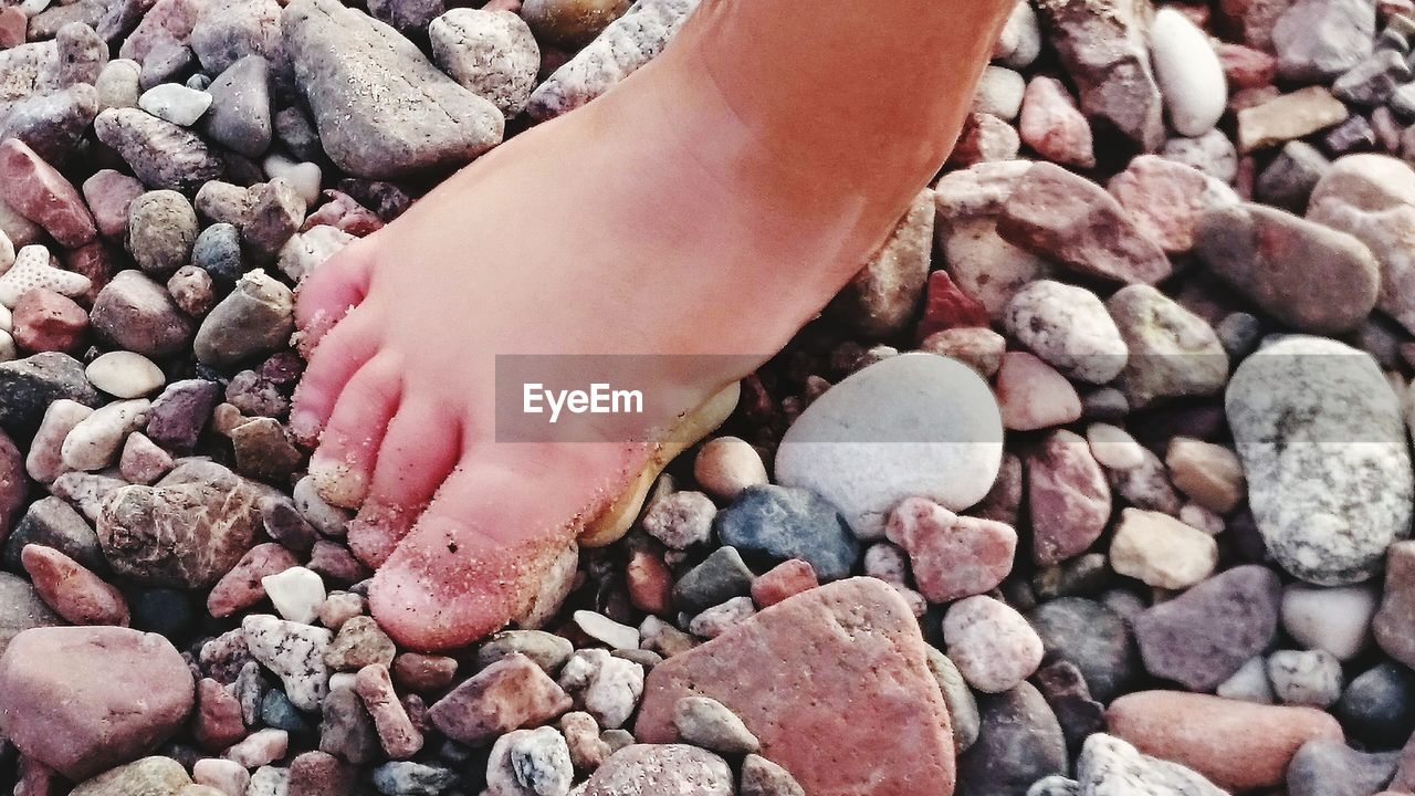 Close-up of barefoot on pebble beach