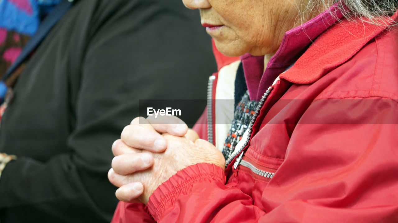 MIDSECTION OF MAN HOLDING WOMAN WITH ARMS RAISED