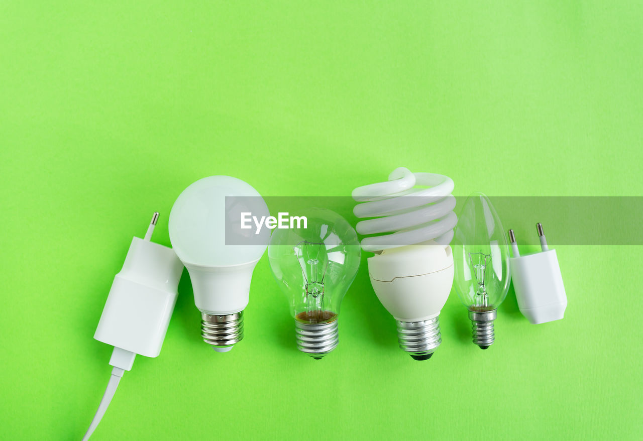 light bulb, lighting, green, colored background, lamp, green background, incandescent light bulb, studio shot, indoors, electricity, white, no people, environmental conservation, lighting equipment, light fixture, light, copy space, energy efficient lightbulb, group of objects, power generation, energy efficient, environment