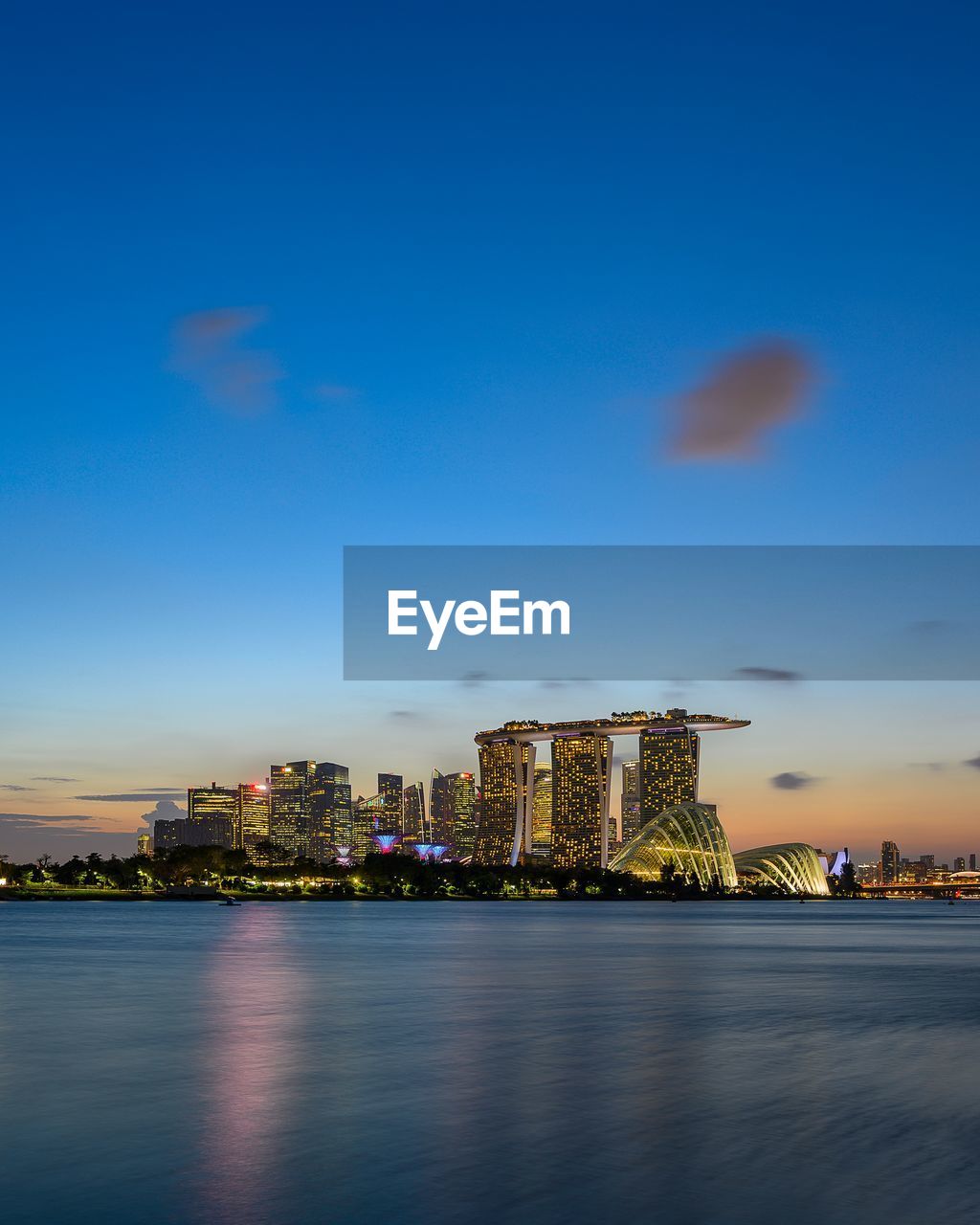 Illuminated buildings in city at waterfront