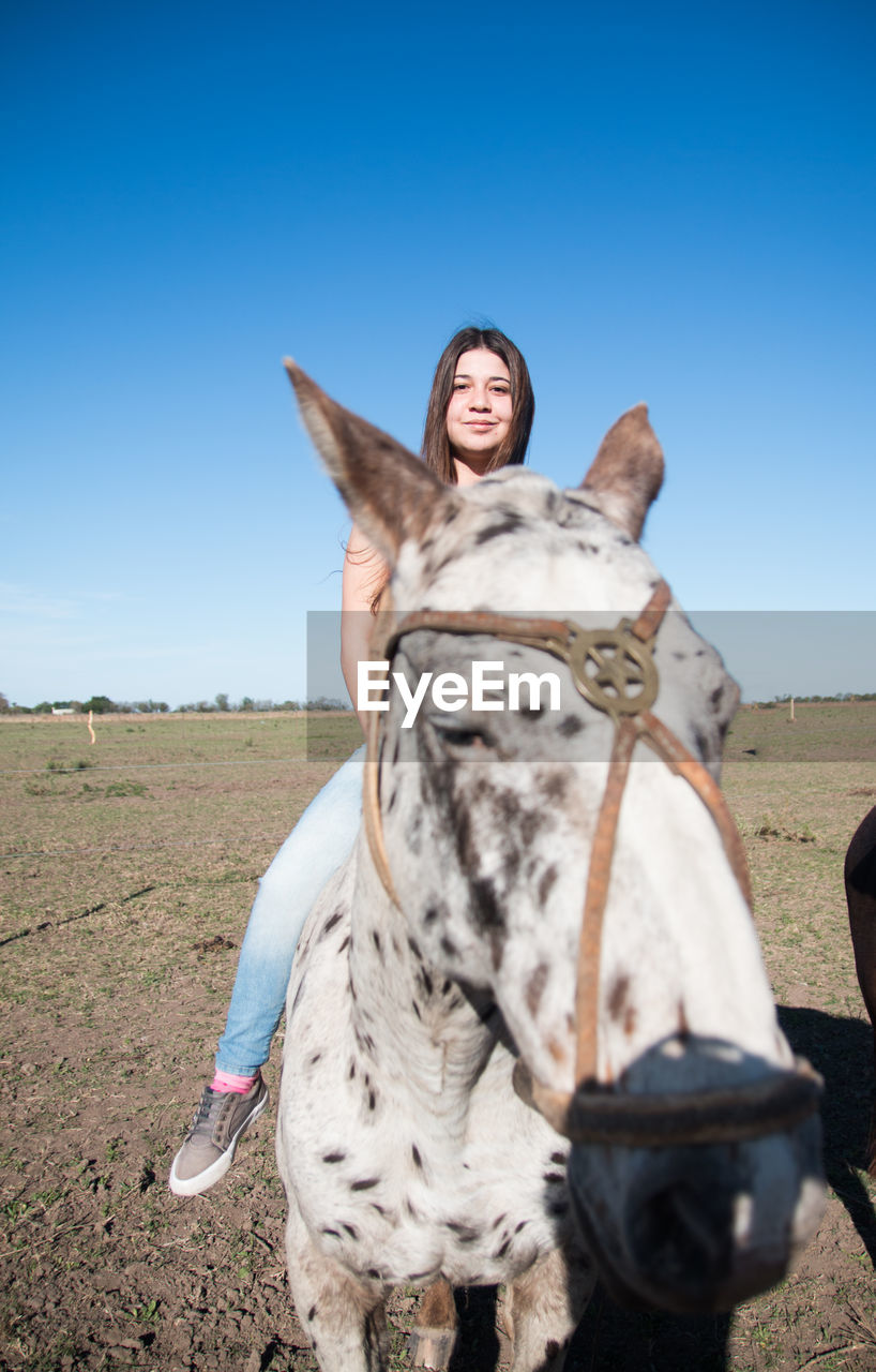 Portrait of argentinian female teenager riding horse