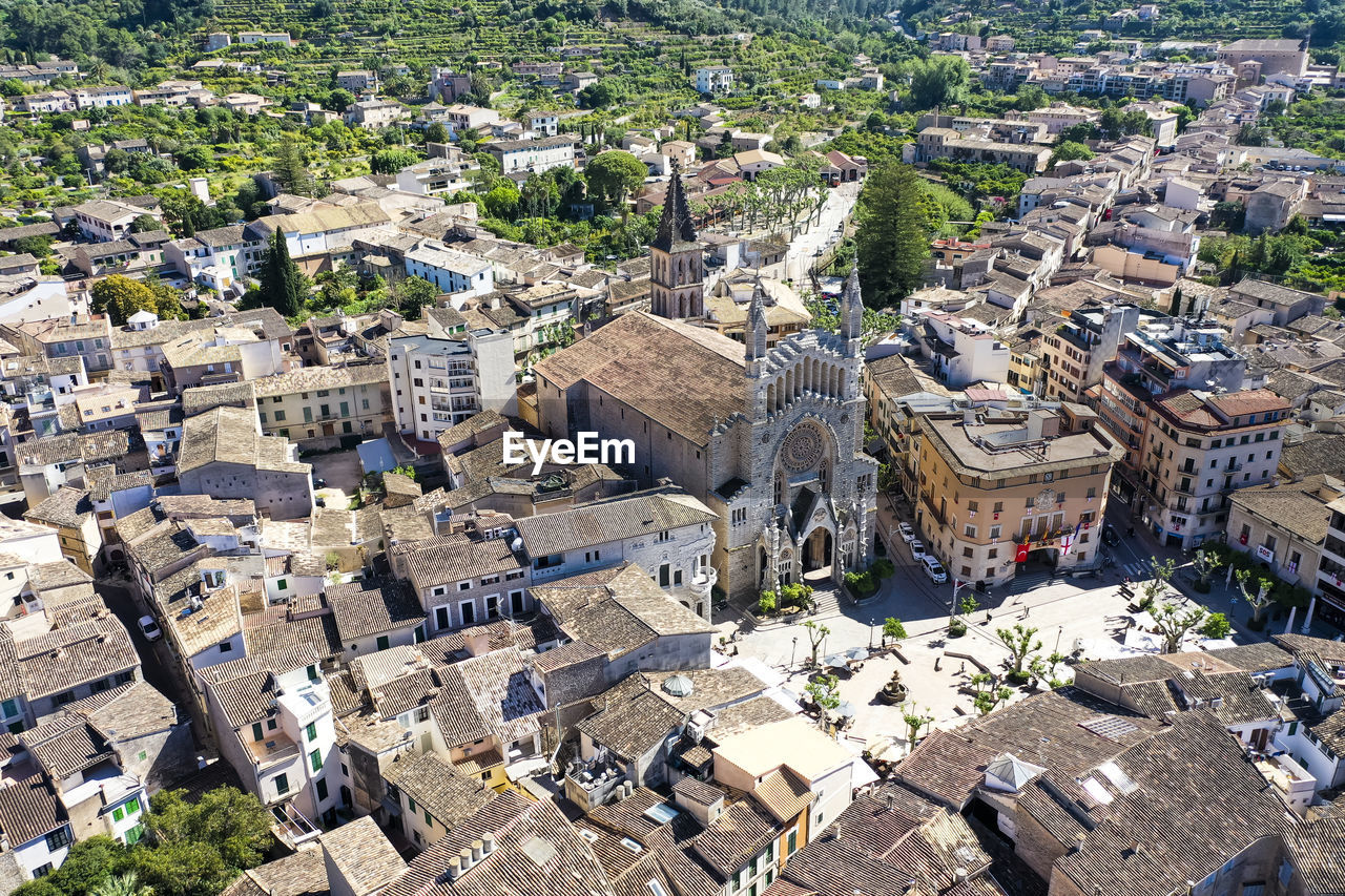 Spain, balearic islands, soller, helicopter view of church of saint bartholomew and surrounding houses in summer
