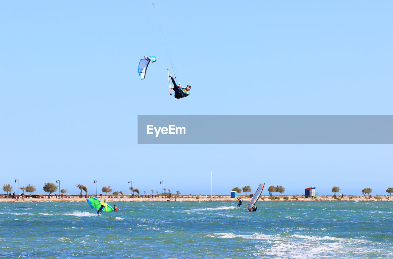 Man kiteboarding over sea against sky