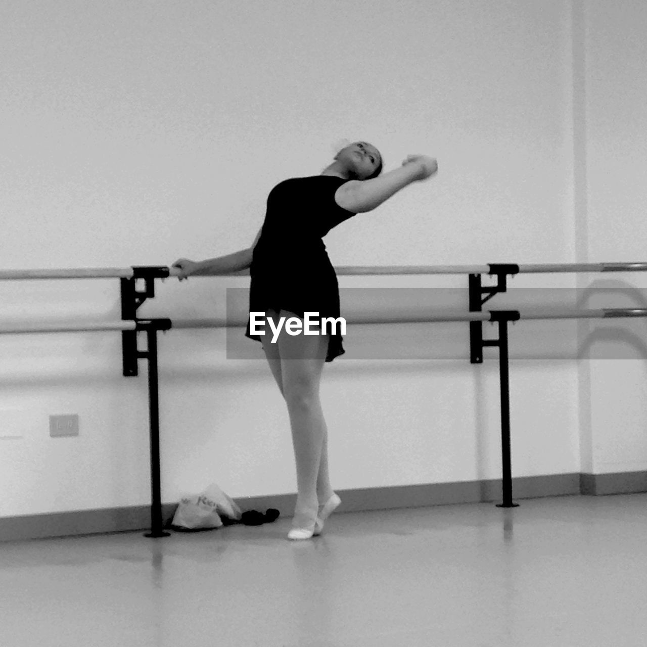 Full length of ballerina practicing at dance studio