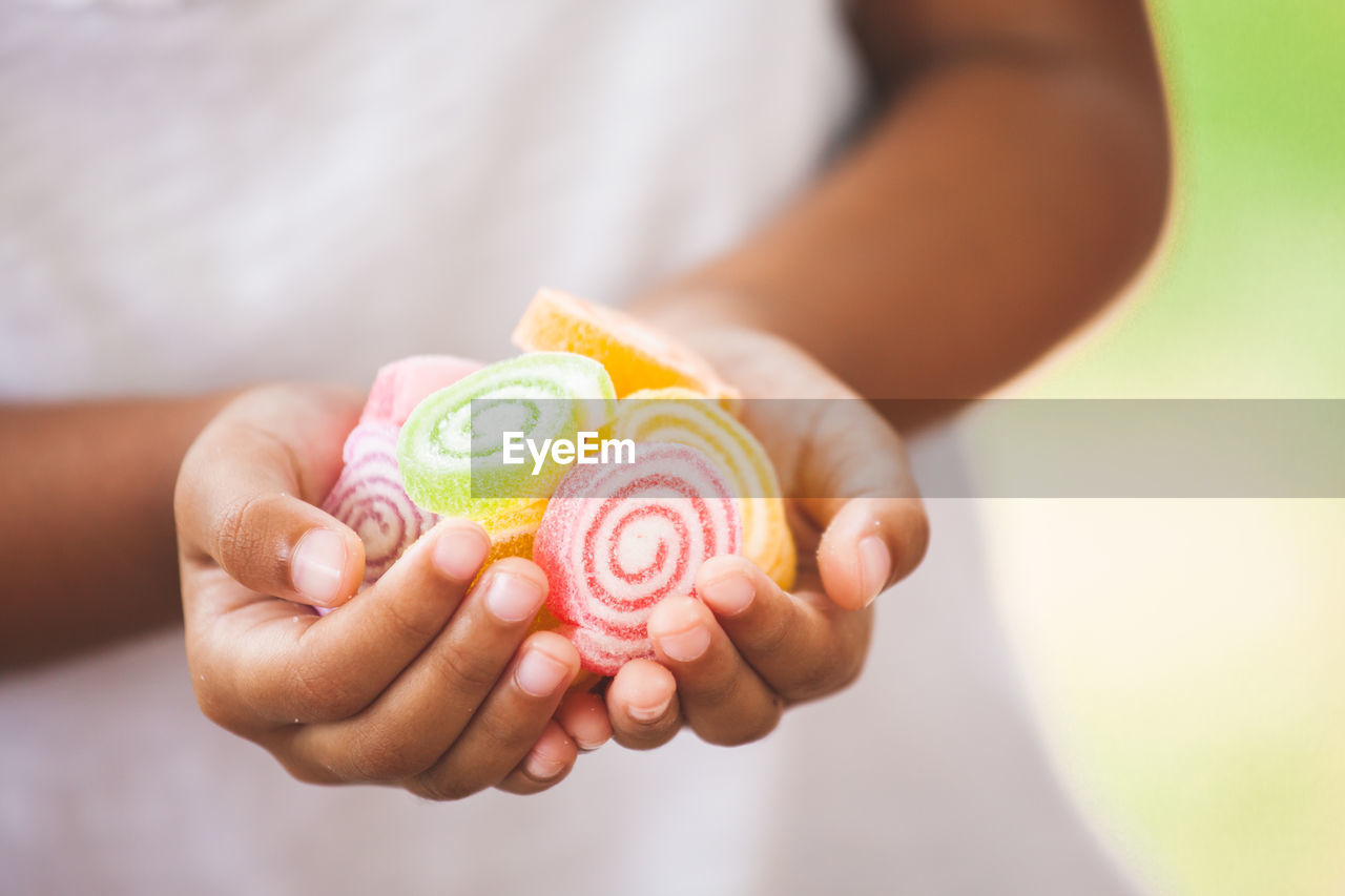 Midsection of girl holding sweet food