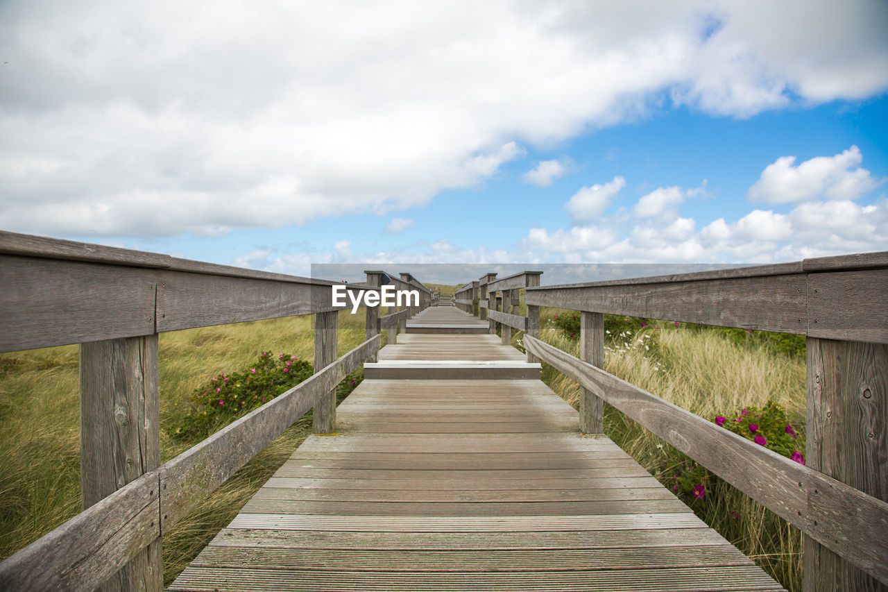 View of footbridge against blue sky