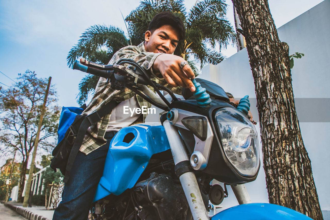 Portrait of young man sitting on motorcycle