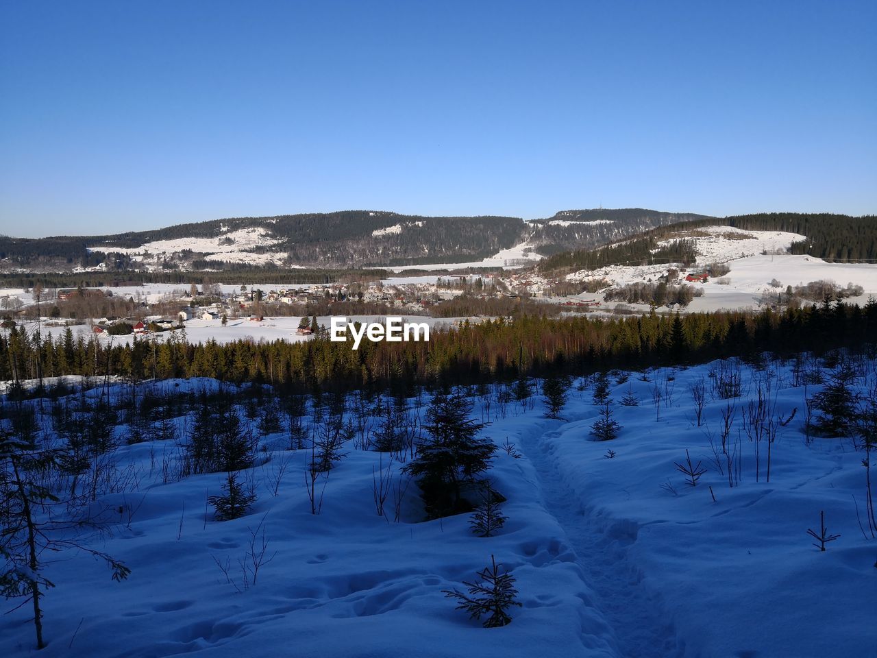 Scenic view of frozen lake against clear blue sky