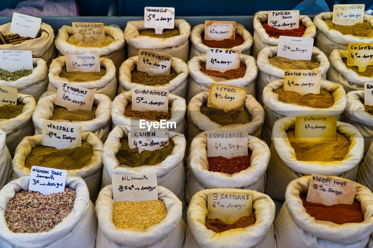 High angle view of spices with labels in sacks at market stall