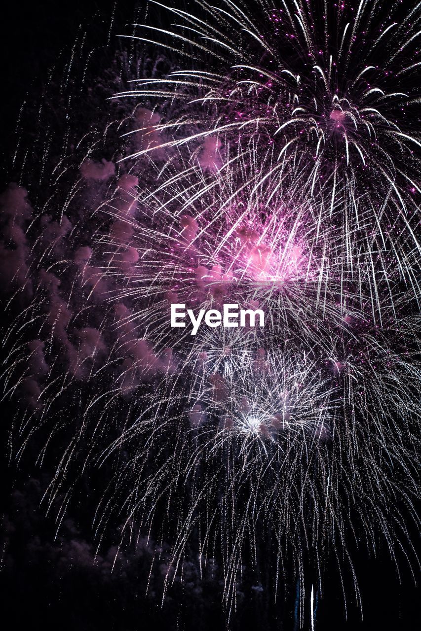 Low angle view of firework display at night