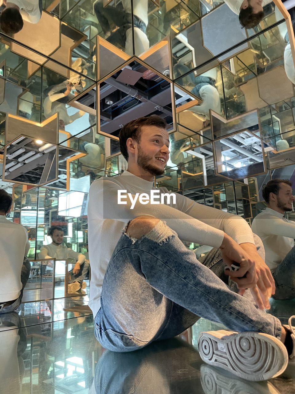 FULL LENGTH PORTRAIT OF YOUNG MAN SITTING AT OFFICE