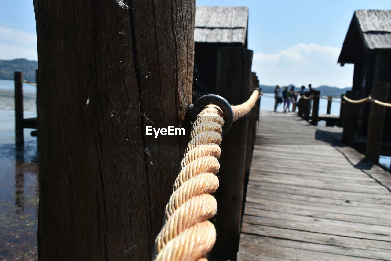 wood, water, pier, nature, sky, day, rope, architecture, post, jetty, sea, built structure, outdoors, boardwalk, transportation, wooden post, no people, sunlight, beach, nautical vessel, walkway, cloud