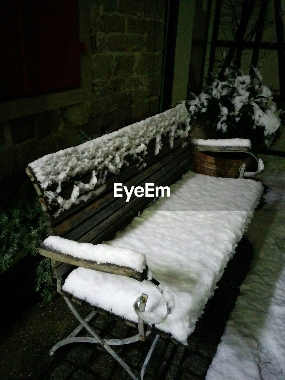 Side view of snow covered bench