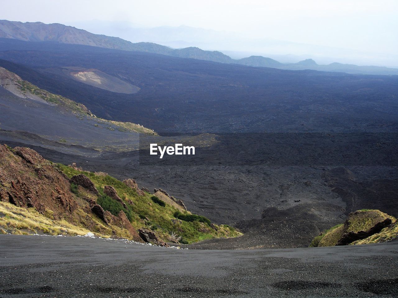 Scenic view of road by mountains against sky