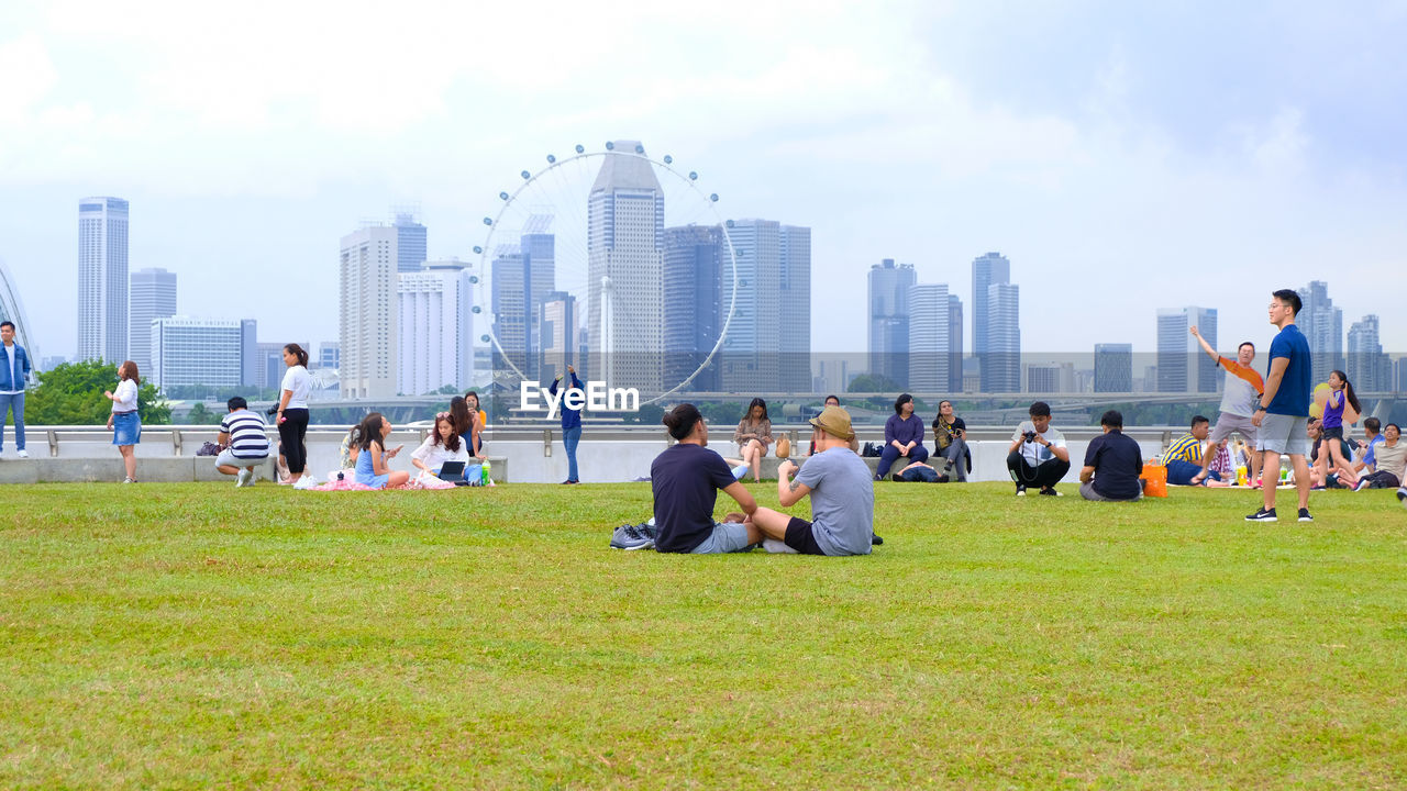 GROUP OF PEOPLE IN FRONT OF MODERN BUILDINGS