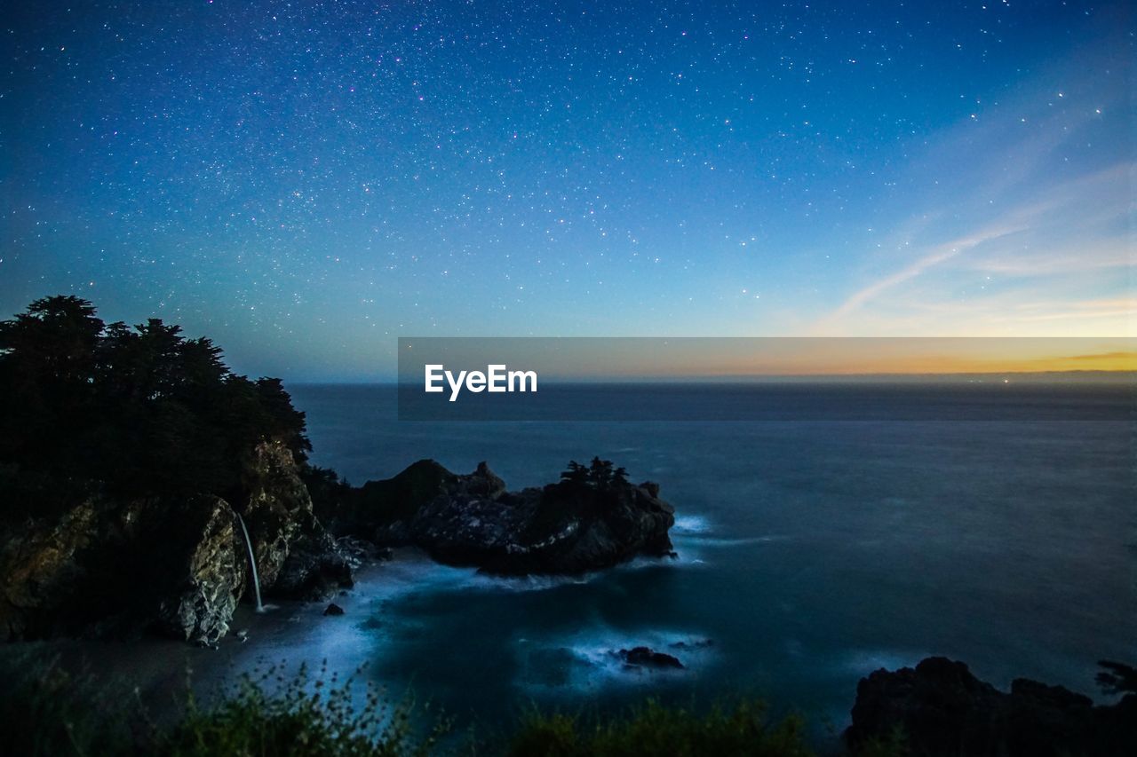 Mcway falls in big sur against star field during sunset