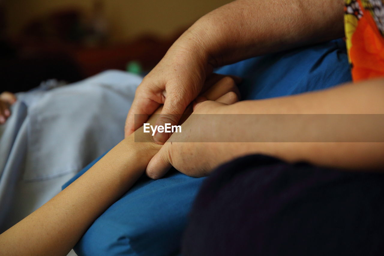 Cropped hand of woman massaging person at hospital