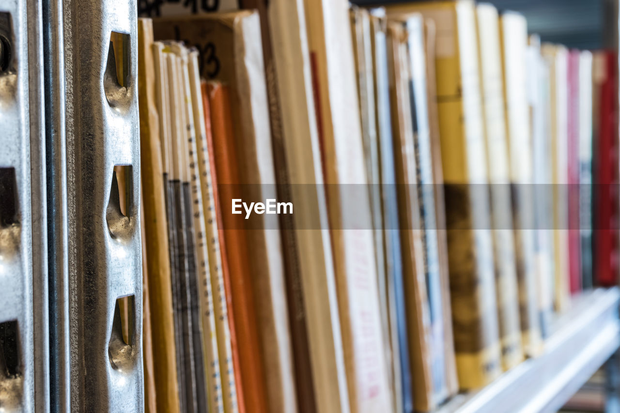 CLOSE-UP OF BOOKS ON SHELF IN LIBRARY