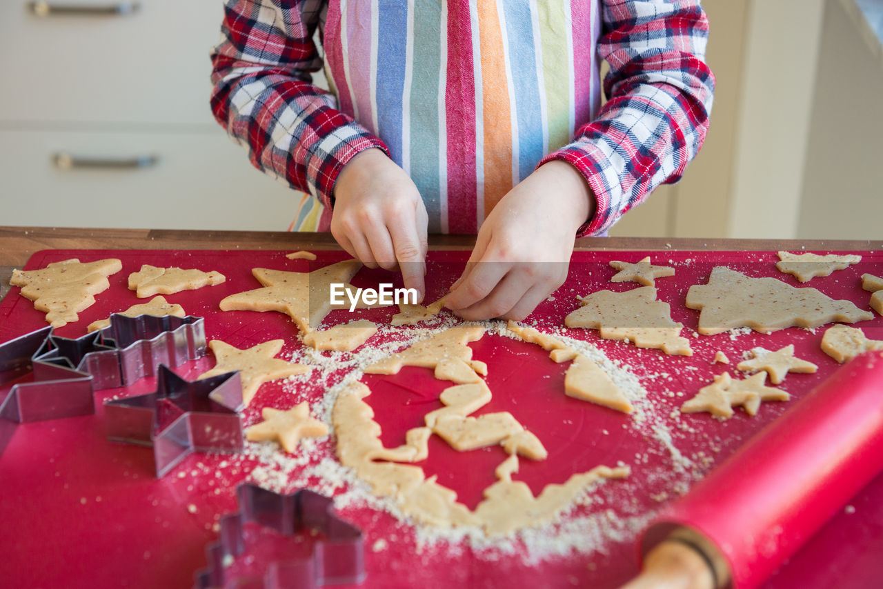 HIGH ANGLE VIEW OF HAND HOLDING COOKIES ON TABLE