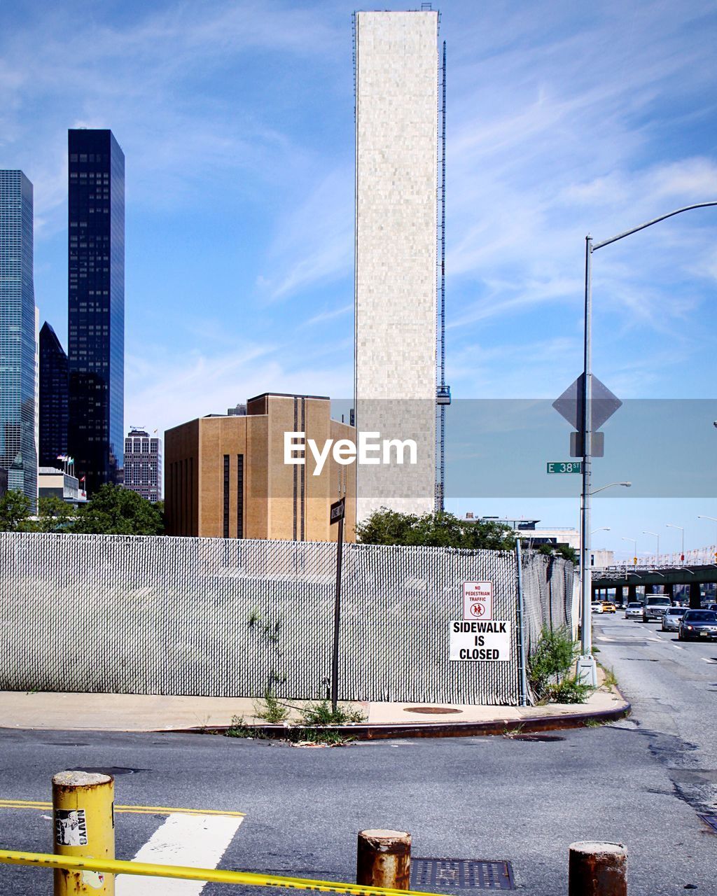 ROAD BY MODERN BUILDINGS AGAINST SKY