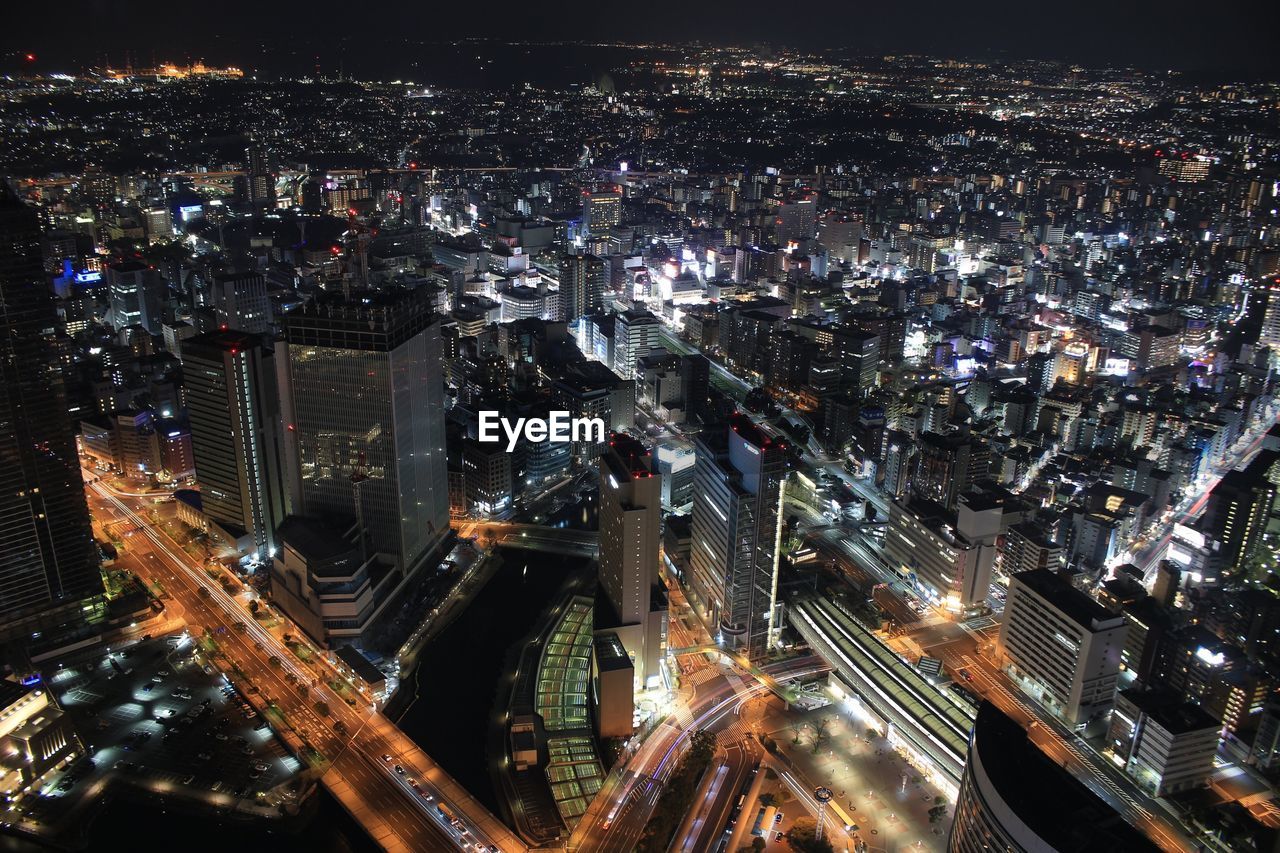 High angle view of illuminated street amidst buildings at night