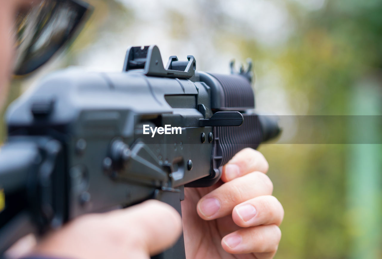 cropped image of person holding gun