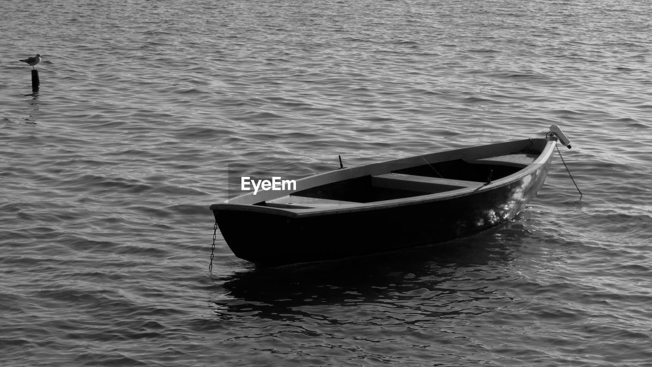 water, boat, nautical vessel, transportation, mode of transportation, vehicle, black and white, sea, nature, monochrome photography, day, rippled, no people, speedboat, waterfront, monochrome, skiff, watercraft, moored, outdoors, dinghy, boating, tranquility, travel, black, rowboat, canoe, beauty in nature, high angle view