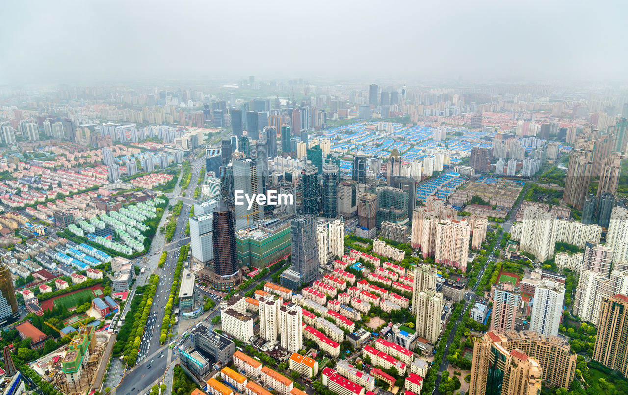 HIGH ANGLE VIEW OF MODERN BUILDINGS IN CITY AGAINST SKY