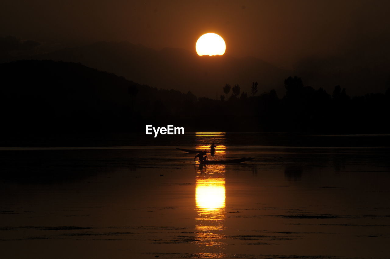 SCENIC VIEW OF LAKE AGAINST SKY AT SUNSET