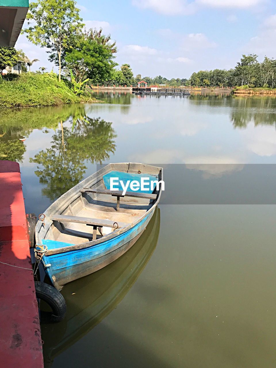 BOATS MOORED IN LAKE AGAINST SKY