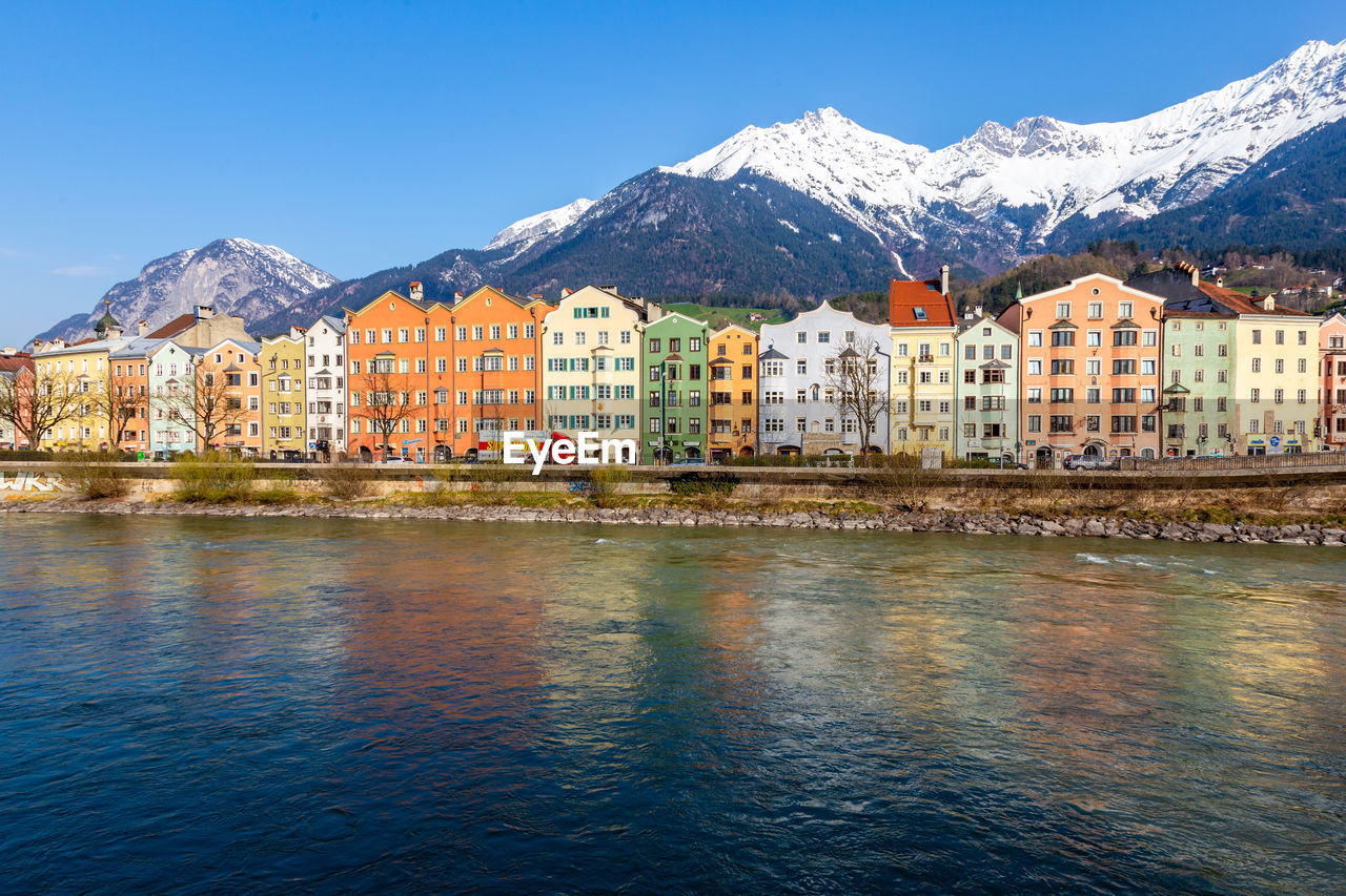Panorama view of colorful buildings and mountains across from the river of innsbruck, austria