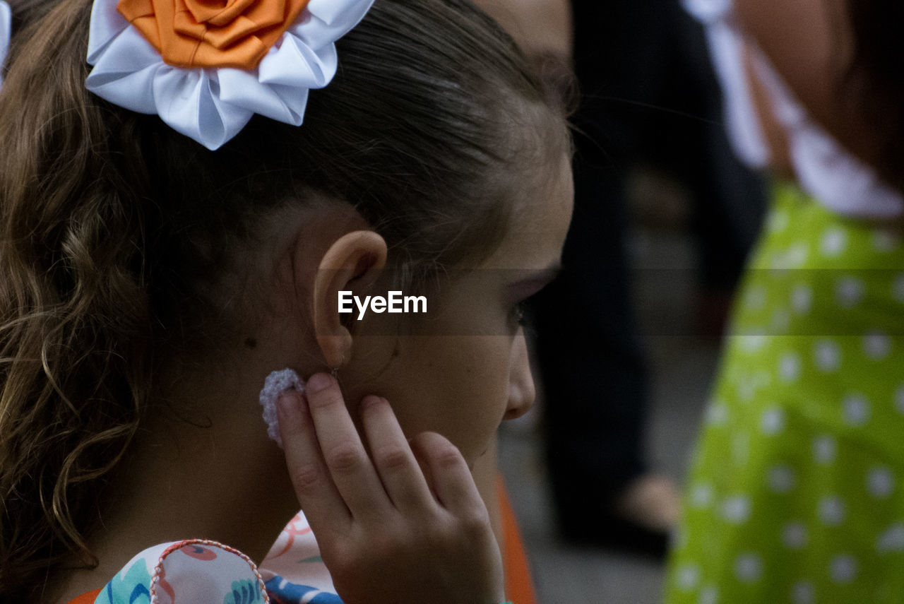 Side view of girl wearing earring outdoors