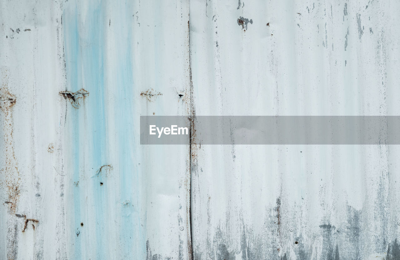 Galvanized sheet painted with white color. empty white wall texture background. peeling paint.