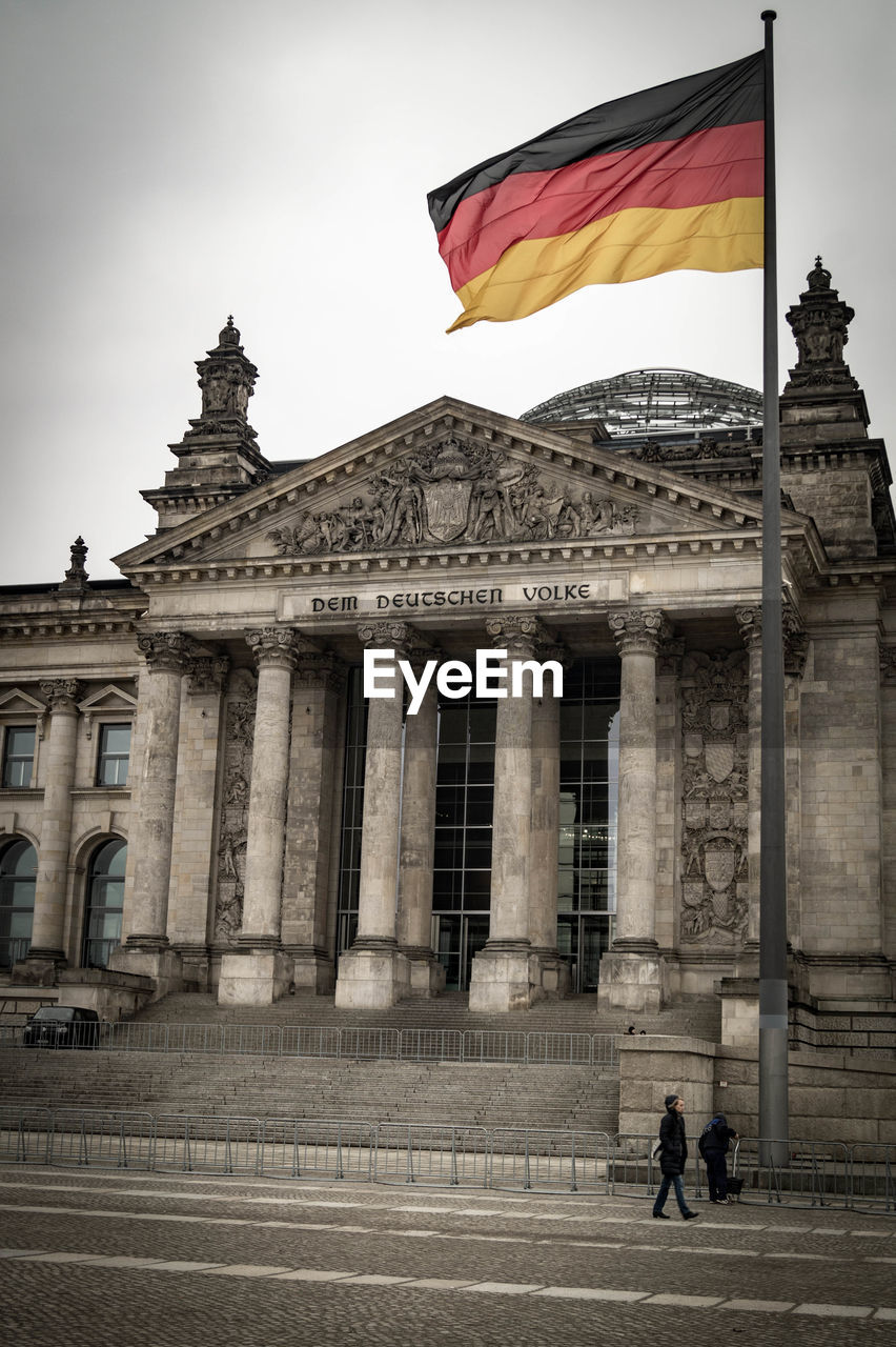 German flag waving outside the reichstag against clear sky