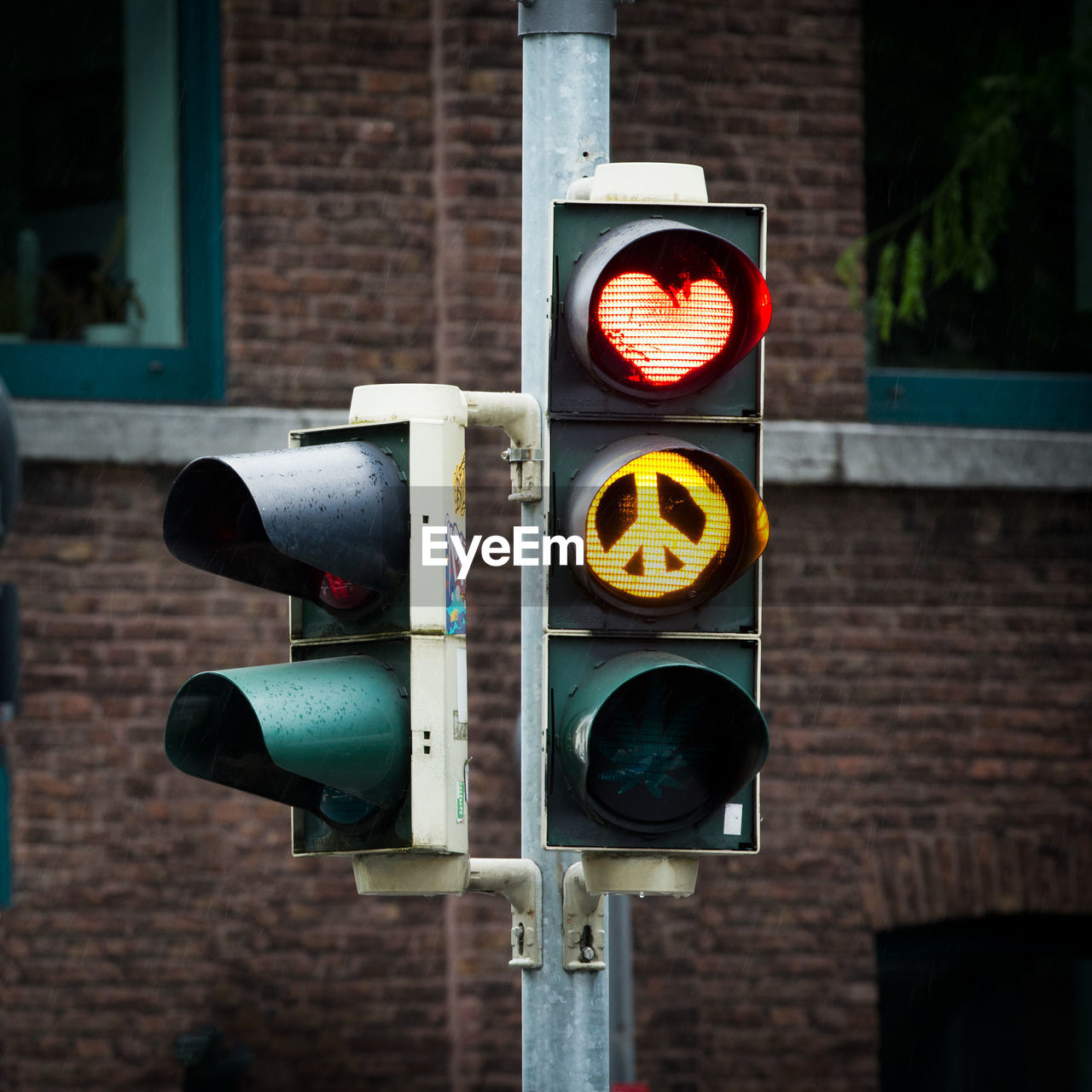 Illuminated stoplight against building in city