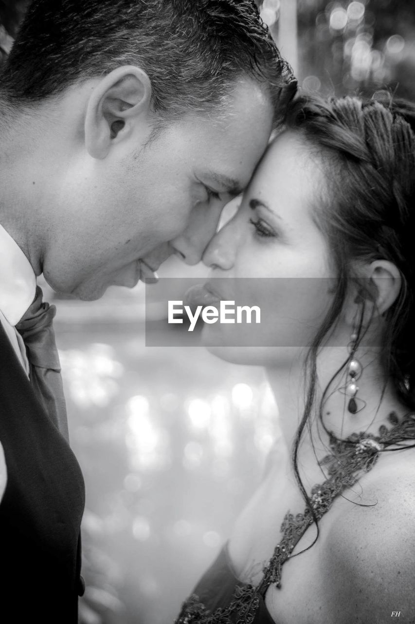 Close-up of bride and groom with face to face standing outdoors