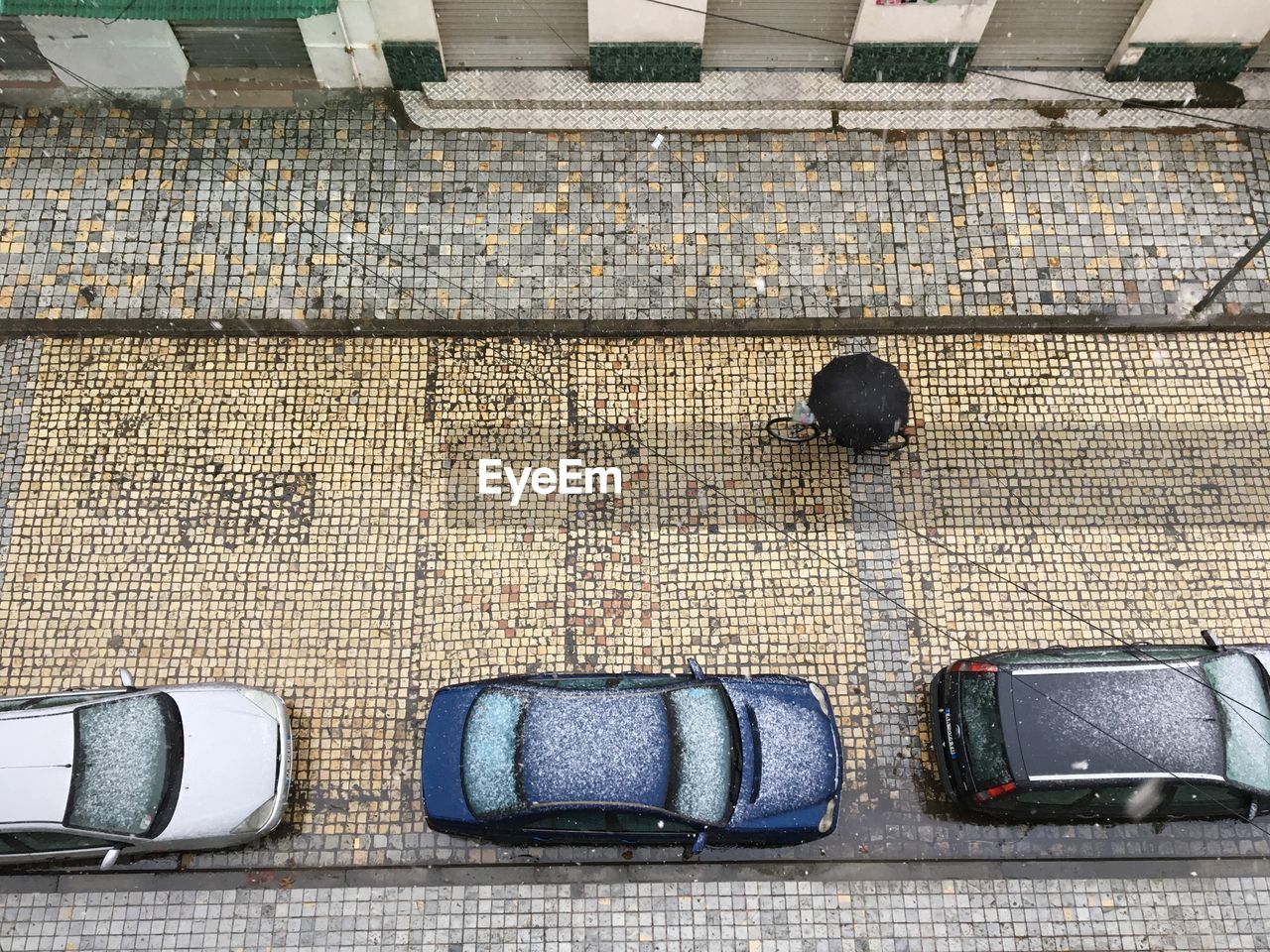 HIGH ANGLE VIEW OF SHOES ON FOOTPATH BY STREET