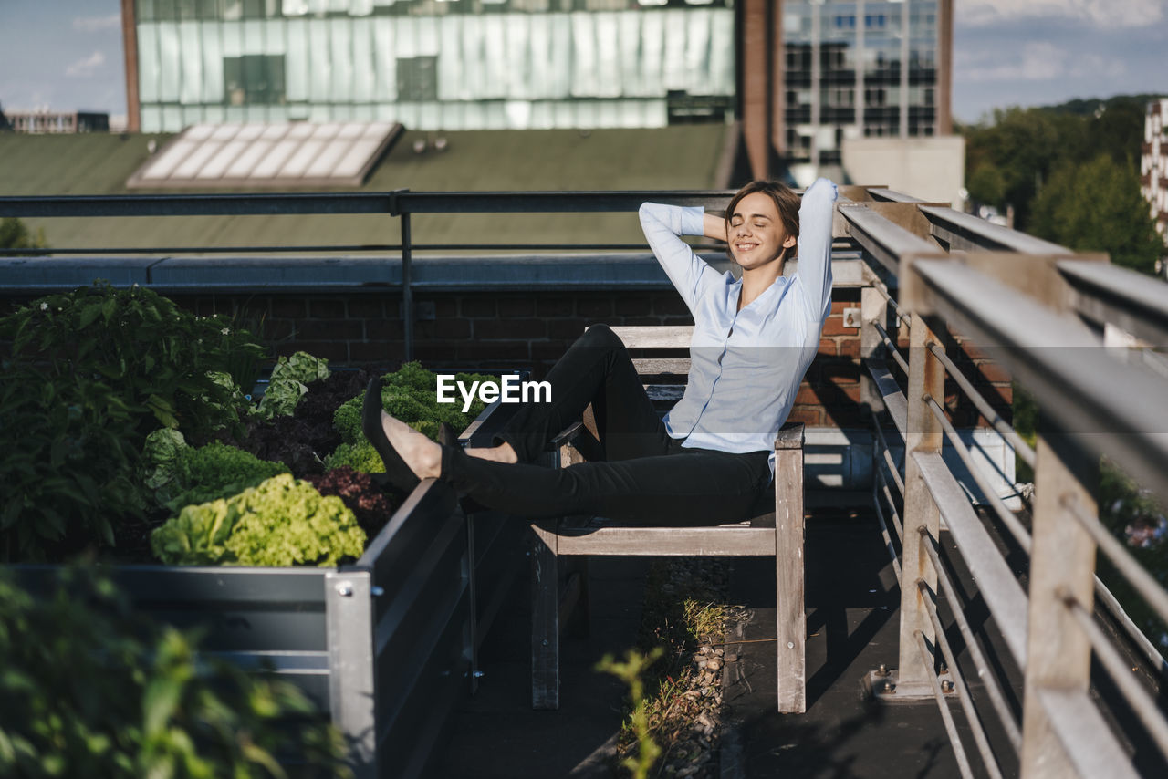 Businesswoman relaxing in his urban rooftop garden