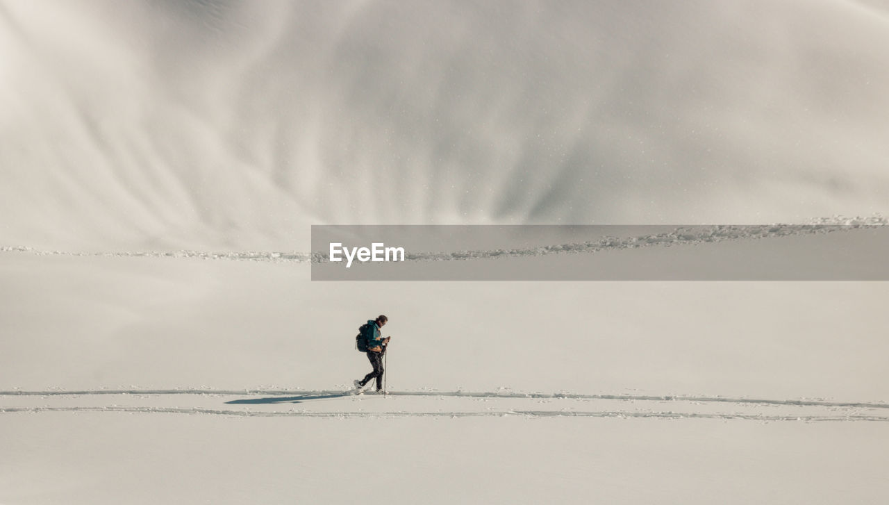 Hiker walking in the snow on the peaks of chamrousse in the alps in isère in france