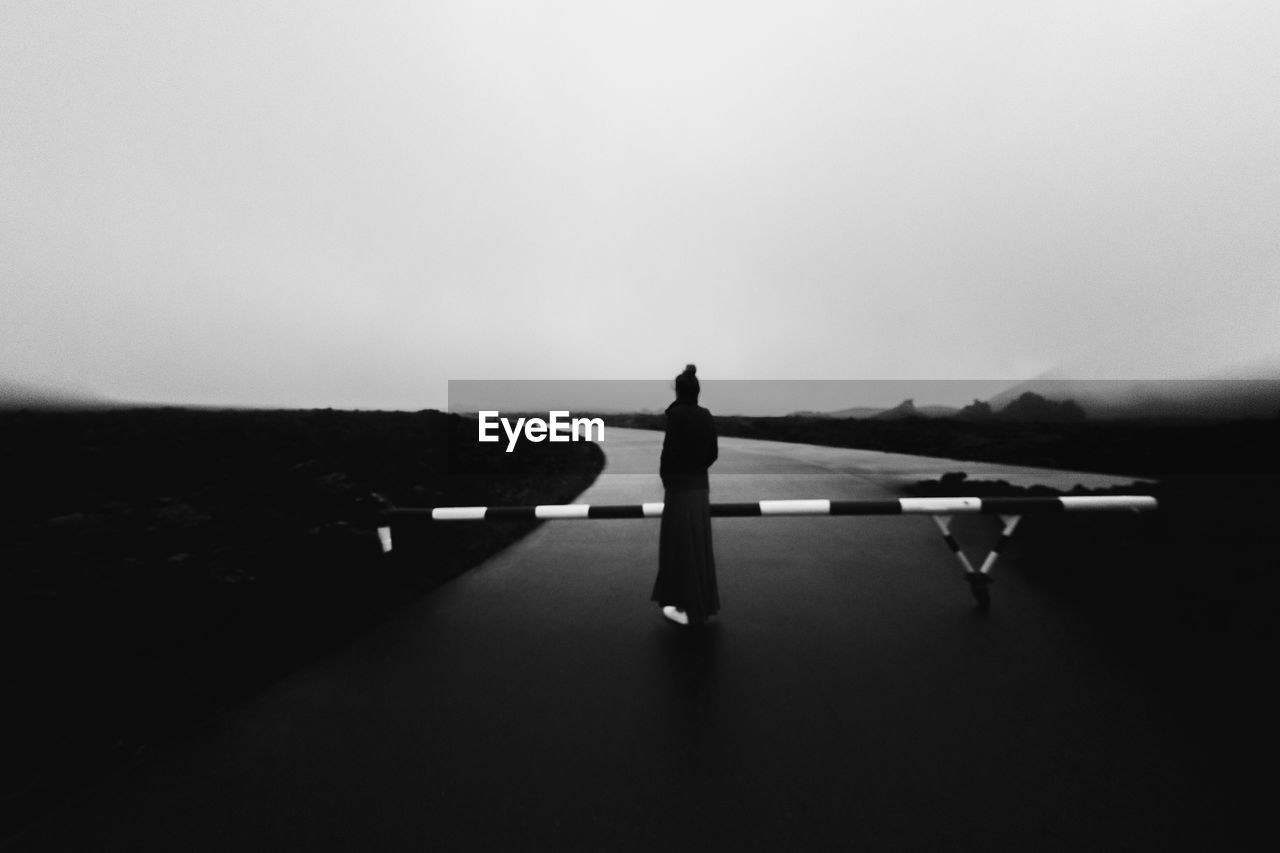 Silhouette woman standing  against sky