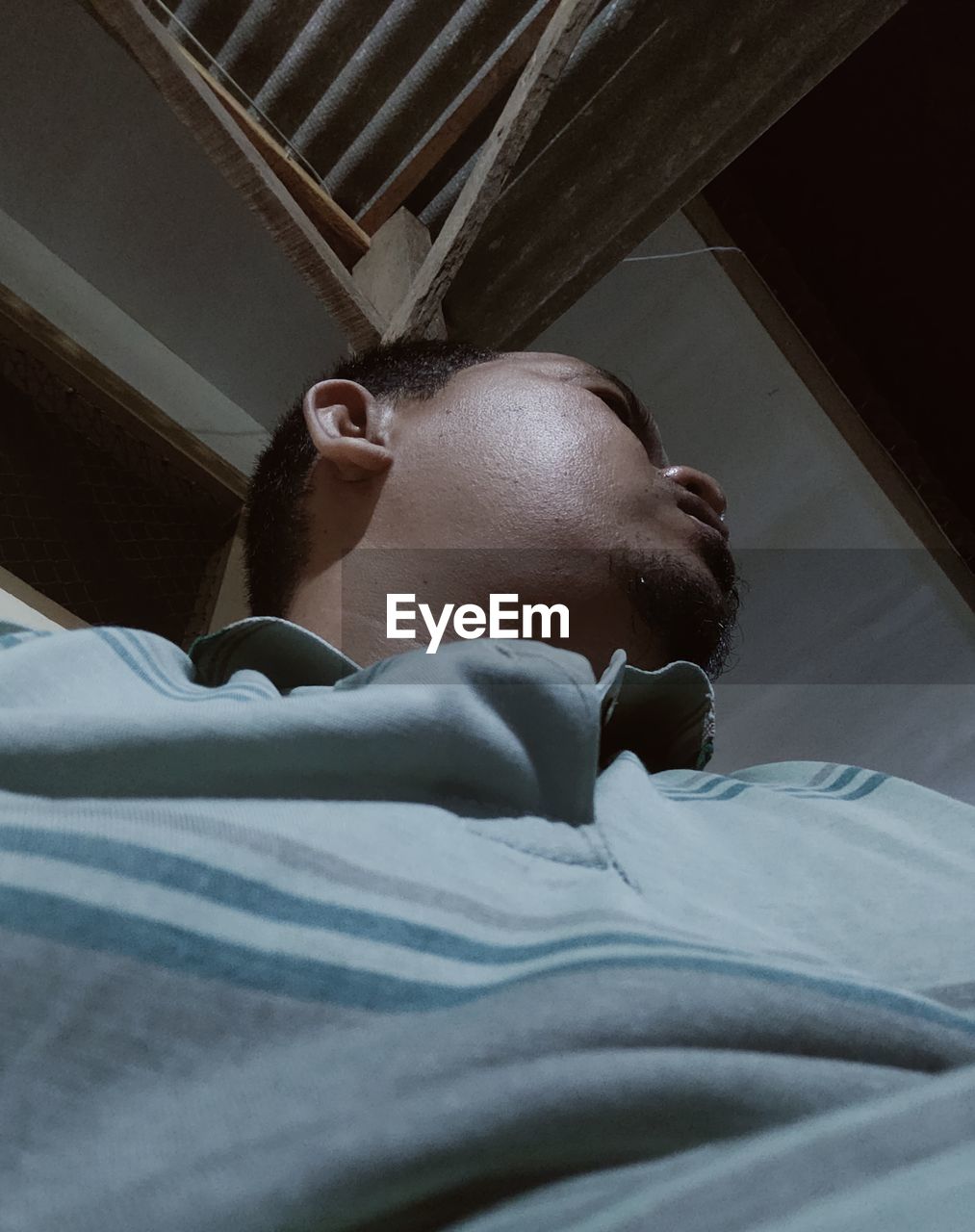 FULL LENGTH PORTRAIT OF YOUNG MAN LYING ON BED