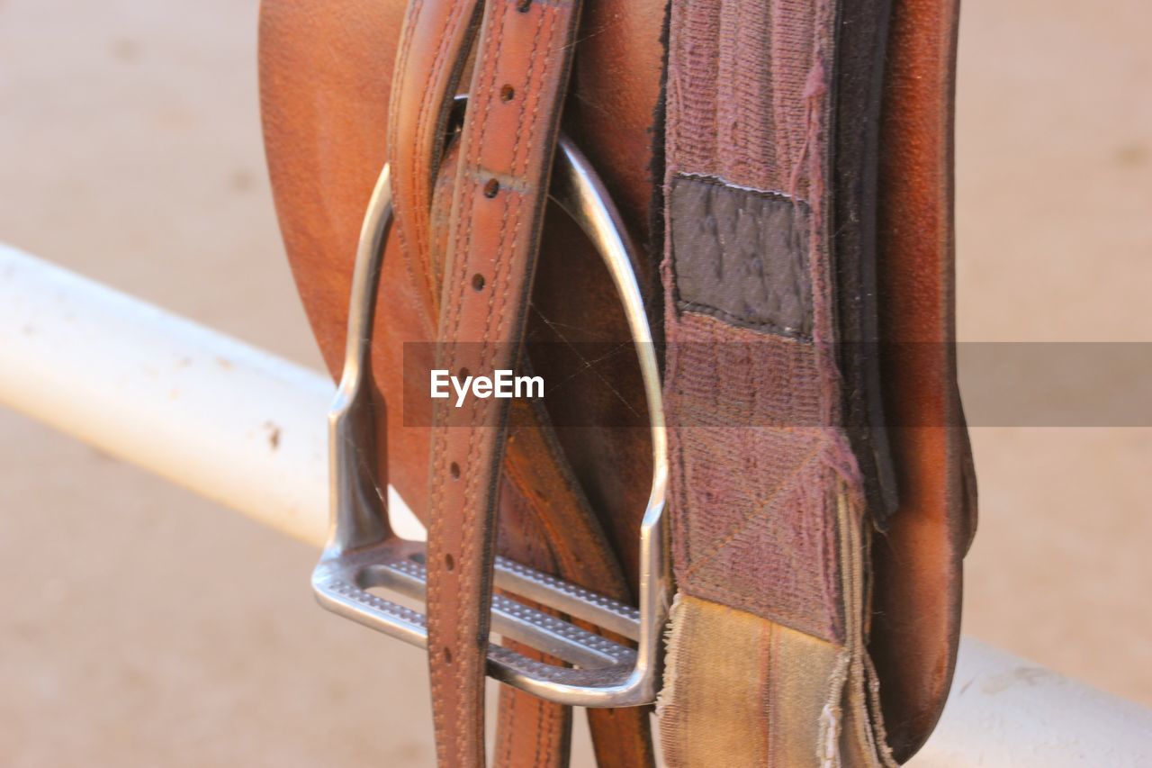 High angle view of saddle on white metallic railing at ranch