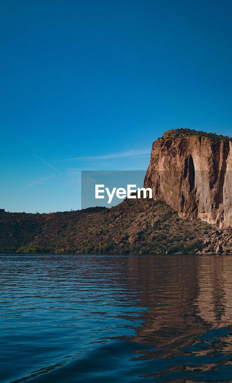 SCENIC VIEW OF ROCK FORMATION IN SEA AGAINST CLEAR BLUE SKY