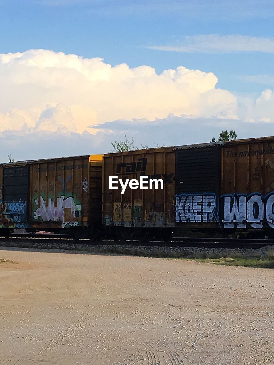 TRAIN AGAINST SKY ON RAILROAD TRACK