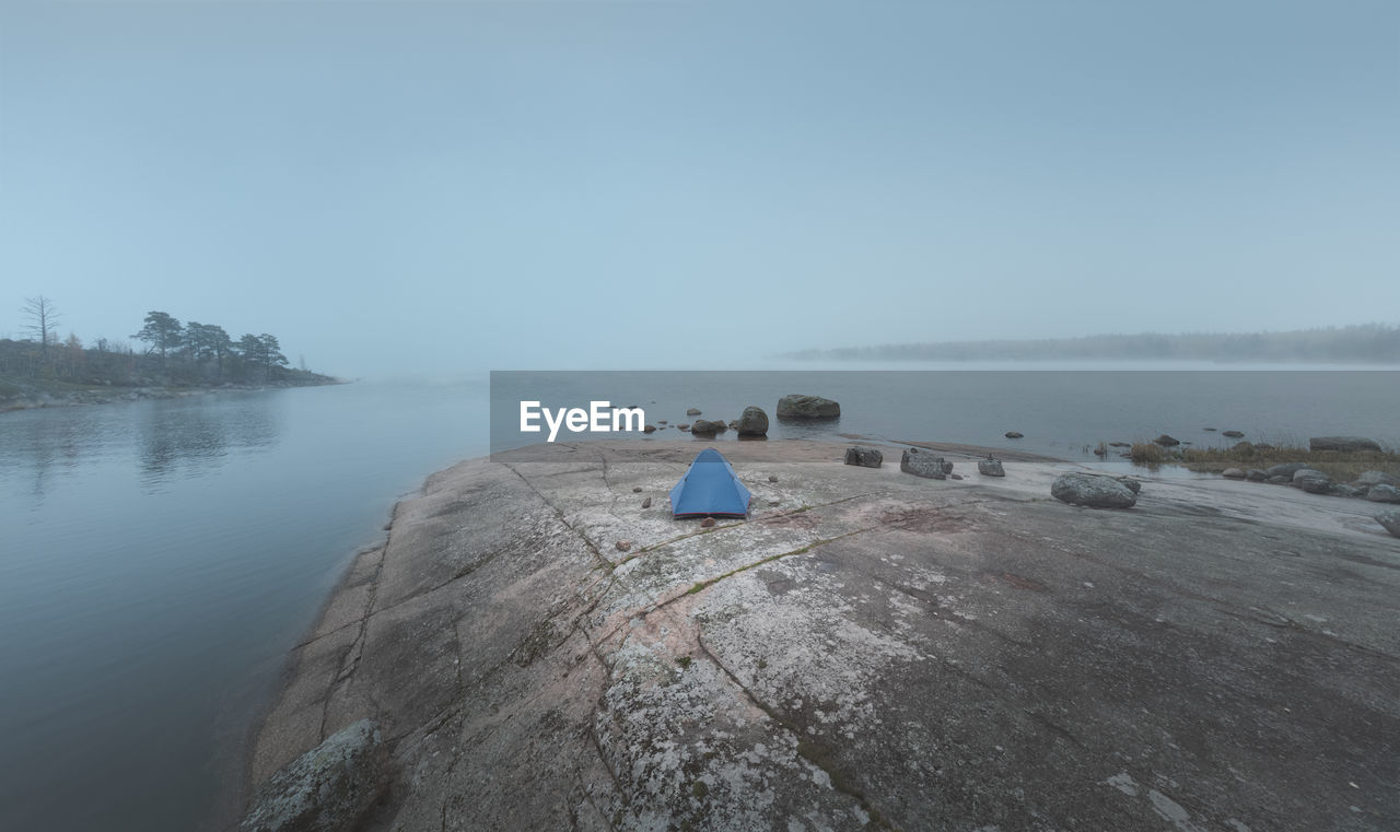 water, sky, sea, nature, scenics - nature, shore, coast, tranquility, beauty in nature, land, tranquil scene, beach, fog, environment, landscape, day, non-urban scene, rock, copy space, outdoors, body of water, ocean, travel destinations, no people, blue, travel, horizon over water, idyllic, tree, bay, horizon, nautical vessel, coastline, holiday, tourism, transportation, relaxation, terrain, vacation, trip