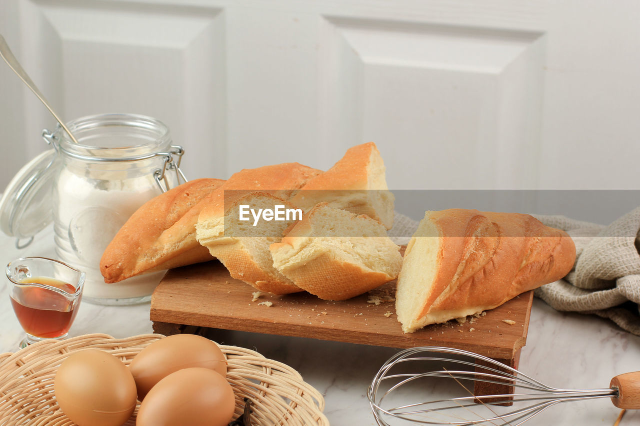 Sliced french baguette with crumbs on white background. 