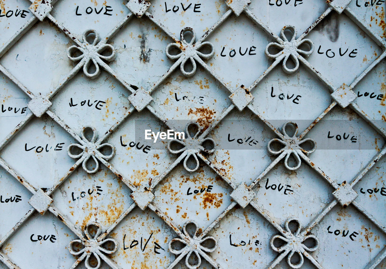 Close-up of metal gate with love text